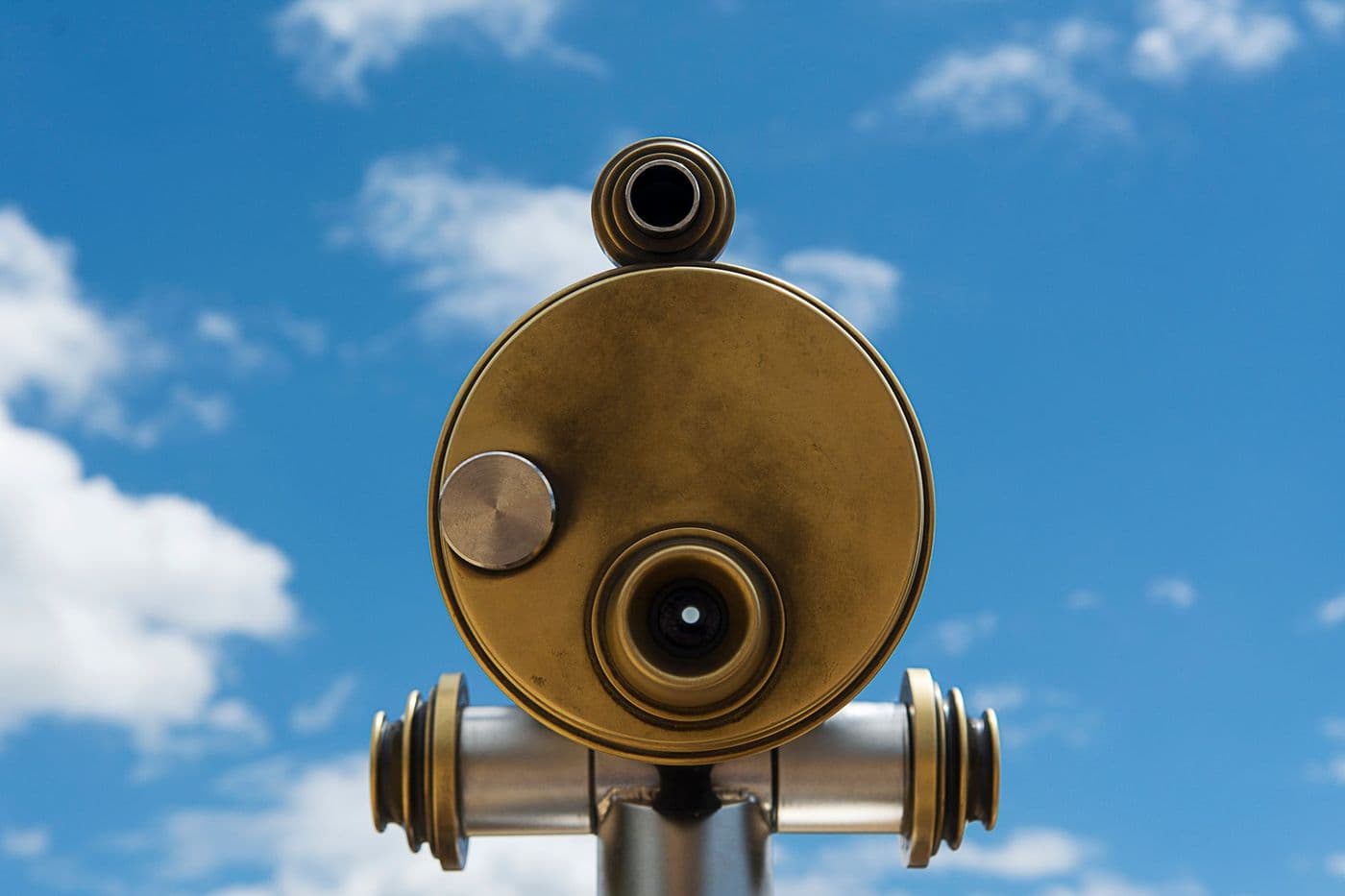 A close-up of a telescope tube against a clear blue sky
