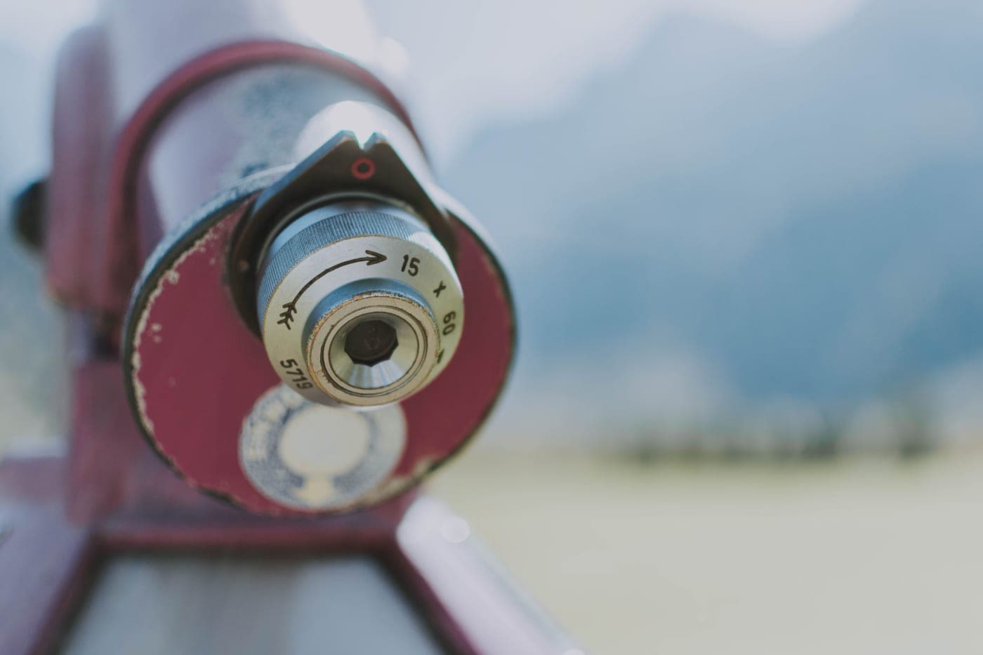 A close-up of a telescope's objective lens against a blurred background
