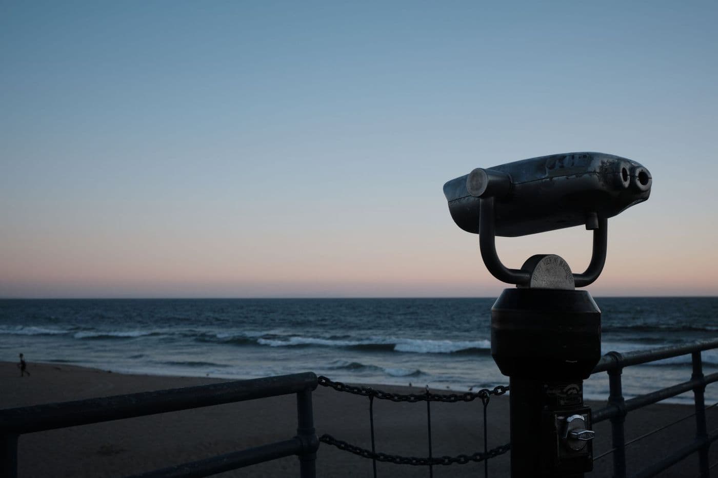 The silhouette of a pair of binoculars on a pier at sunset
