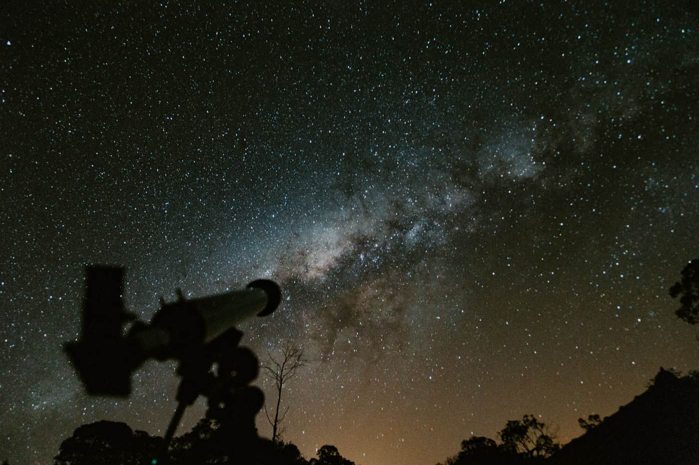 A telescope silhouetted against the Milky Way