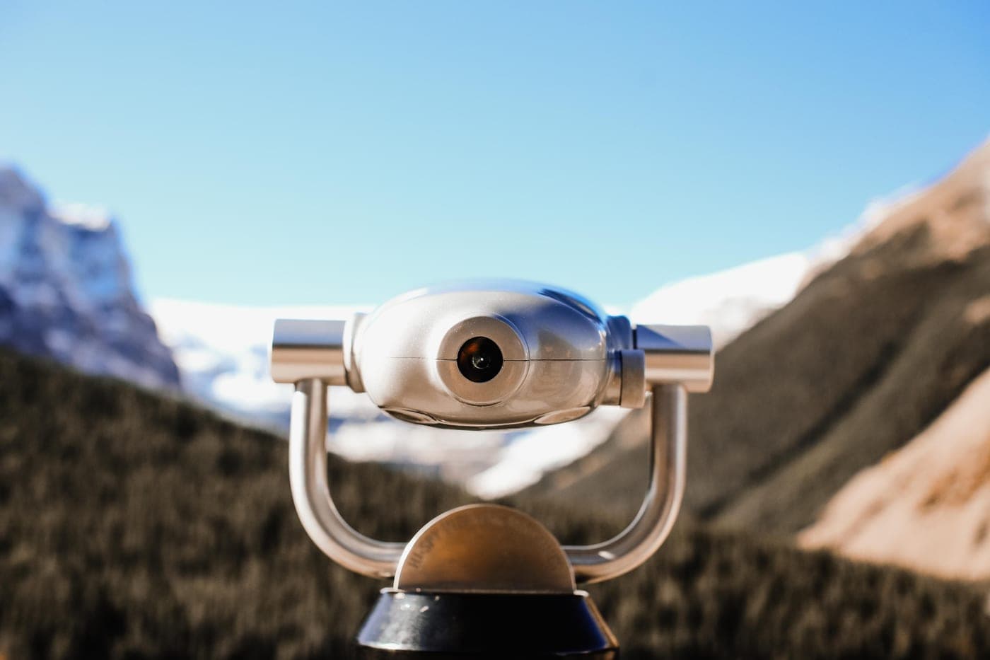 Close-up of binoculars with a mountain landscape behind them