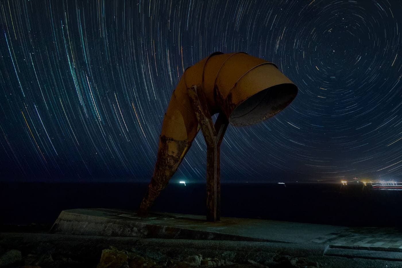 Star trails circling above a telescope structure at night