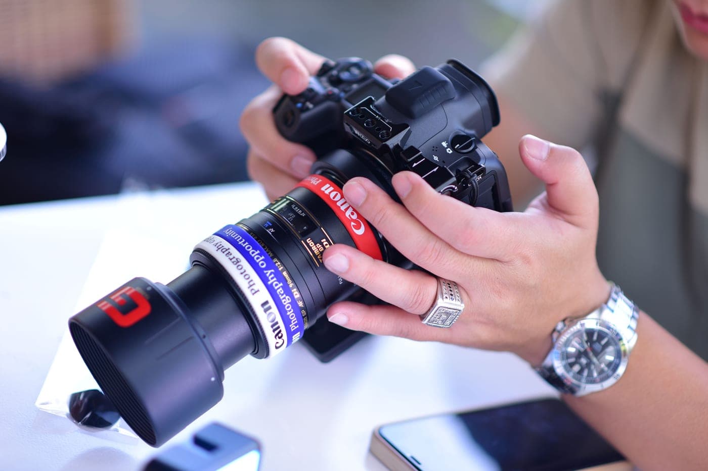 A photographer adjusting a lens focus ring
