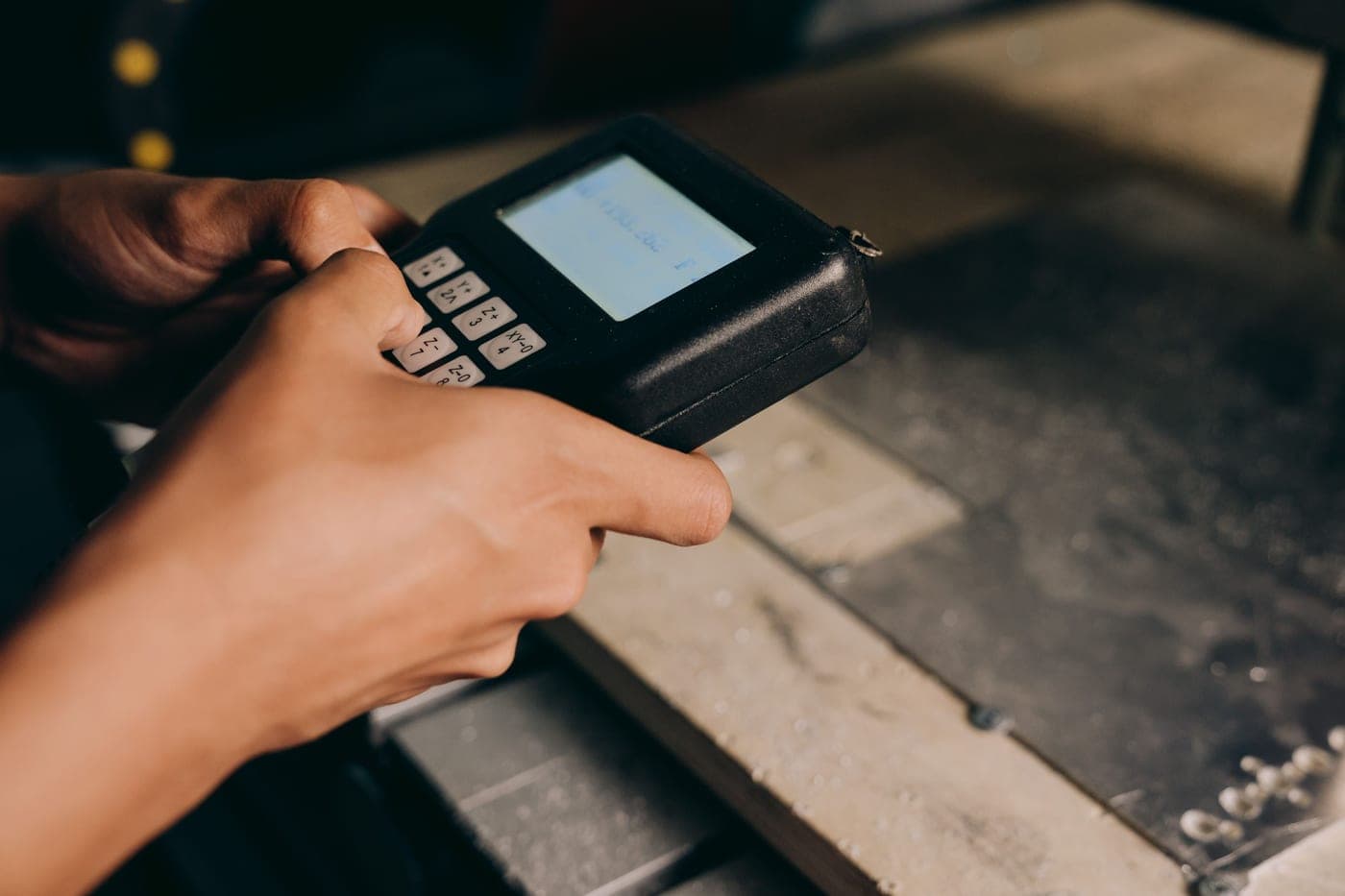 Hands operating a small electronic control unit in low light