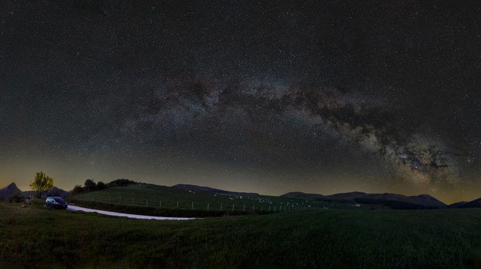 The Milky Way arching over open fields on a clear night