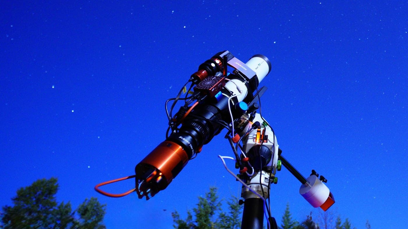A telescope pointed at a starry night sky