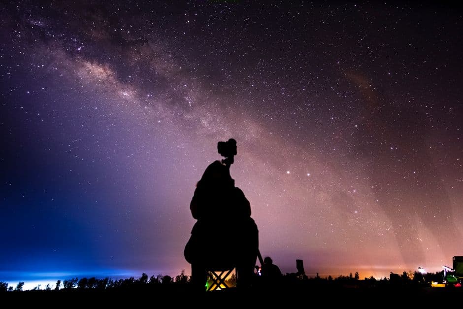 A stargazer silhouetted beneath a dense field of stars