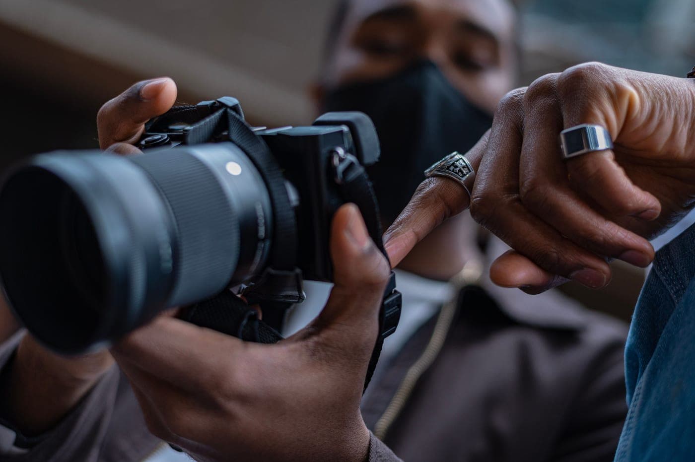 Hands adjusting the controls of a camera indoors