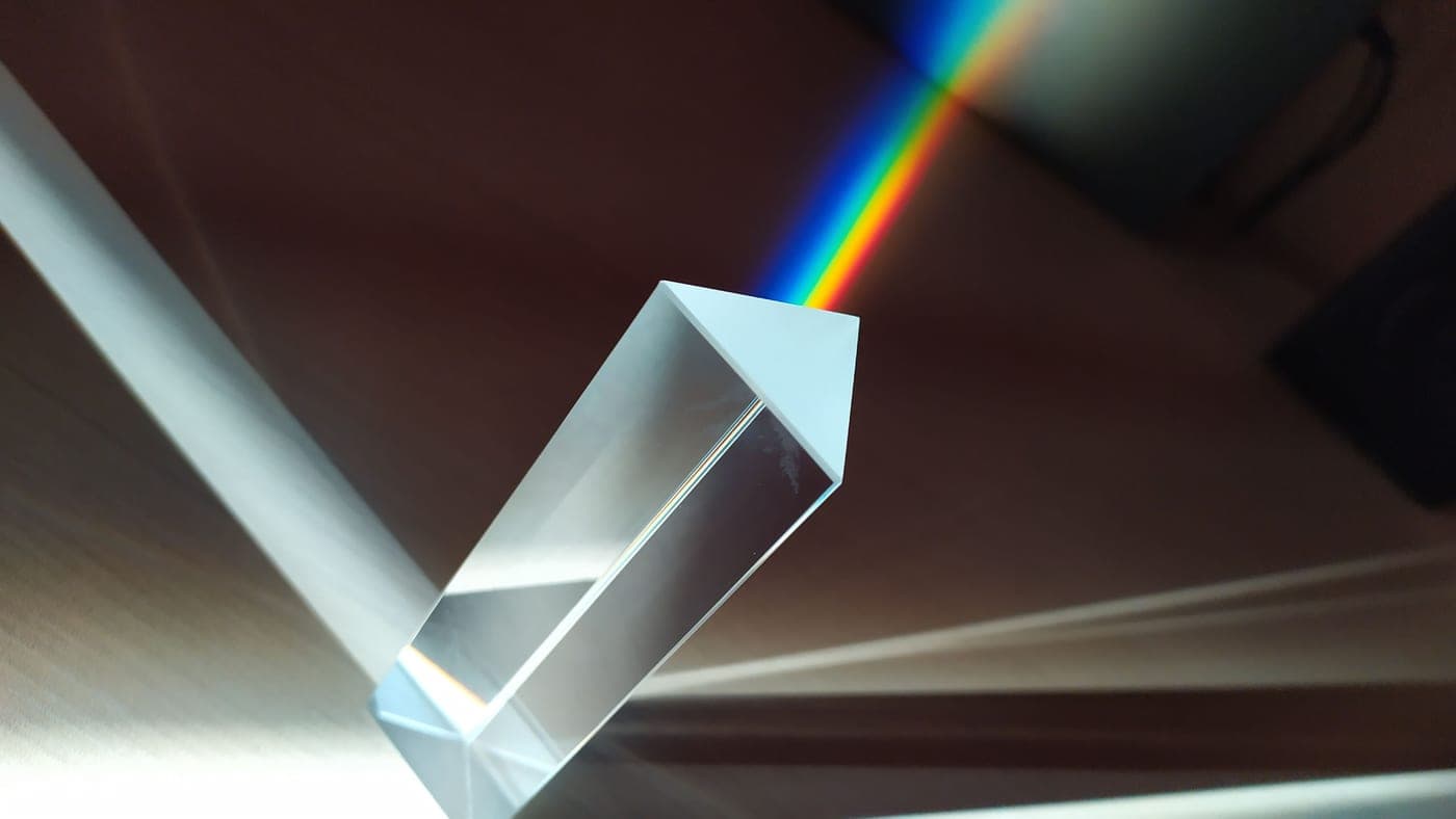 A glass prism splitting light into a band of color